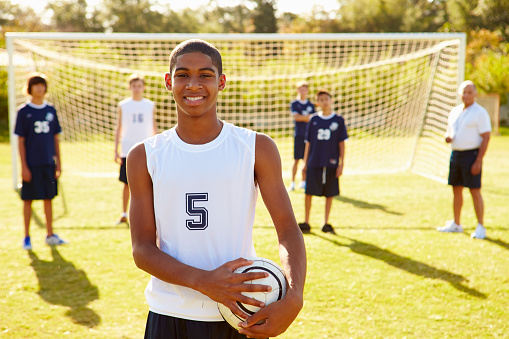 Portrait Of Player In High School Soccer Team Holding Ball Smiling To Camera