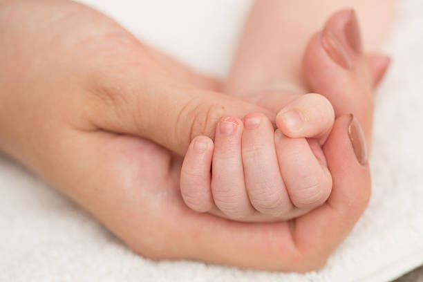istock Baby's hand gripping adult finger 498508997
