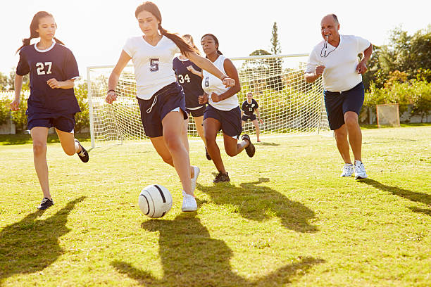membres de femme jouant un match de football à l'école - high school sports photos et images de collection
