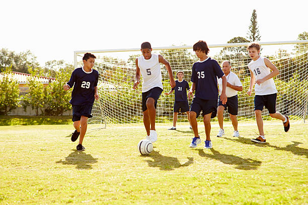 membri di maschio high school giocare partita di calcio - sports uniform athlete competitive sport professional sport foto e immagini stock