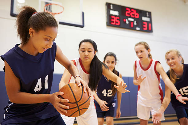 femme jouant un jeu de l'équipe de basketball de l'école - high school sports photos et images de collection