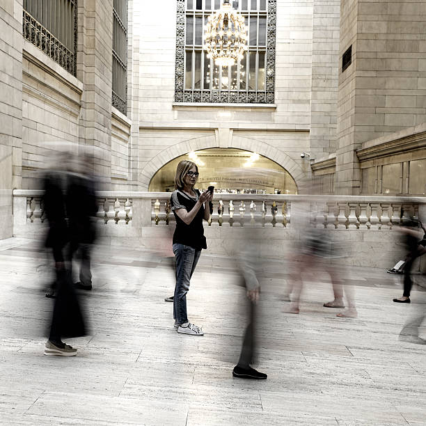 sms di donna al grand central station, new york - business blurred motion text messaging defocused foto e immagini stock
