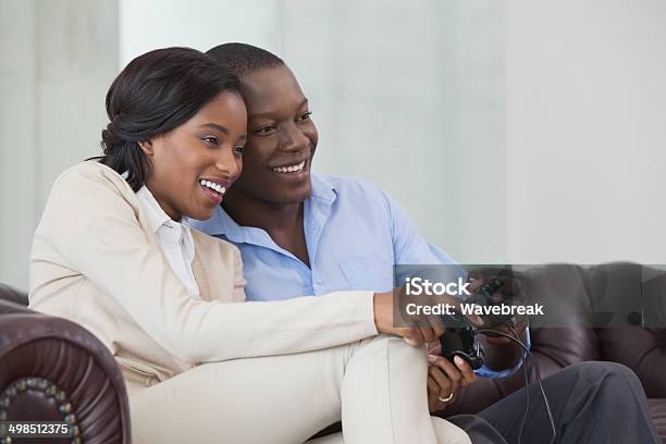 Happy Couple Playing Video Games Together On The Couch Stock Photo - Download Image Now