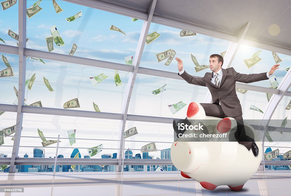 Businessman sitting on white piggy bank in office Businessman sitting on piggy bank on office background 2015 Stock Photo