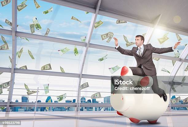 Businessman Sitting On White Piggy Bank In Office Stock Photo - Download Image Now - 2015, Adult, Beautiful People