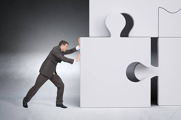 istock Businessman pushing puzzle piece 498525274