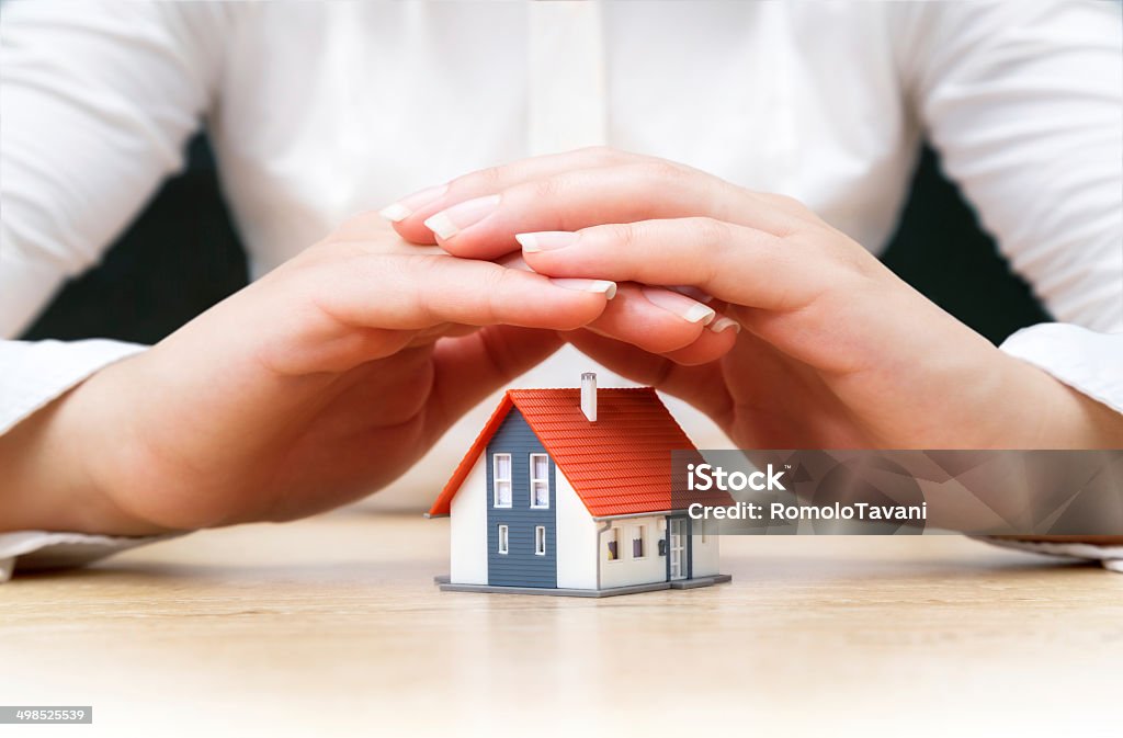 insurance real estate concept house covered of woman hands Home Insurance Stock Photo