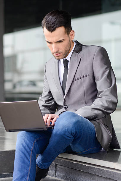 istock Young businessman typing in a laptop computer in urban backgroun 498525701