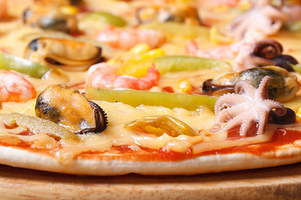 Pizza ai frutti di mare with octopus, mussels and shrimp close-up on the table. horizontal