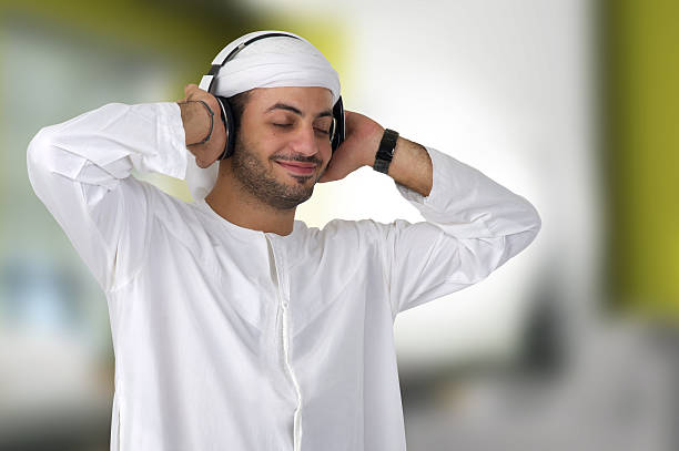 arab homem usando fones de ouvido com as mãos nos ouvidos - traditional clothing audio - fotografias e filmes do acervo