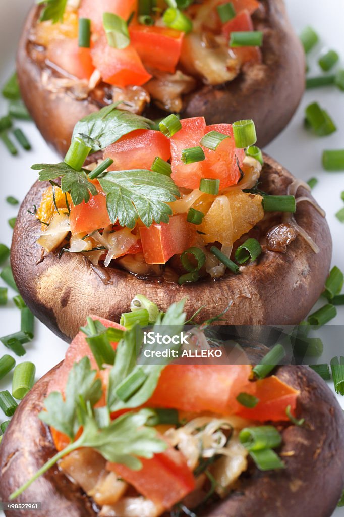 Vegetarian cuisine: stuffed mushrooms macro. Vegetarian cuisine: stuffed mushrooms with vegetables macro. vertical Appetizer Stock Photo