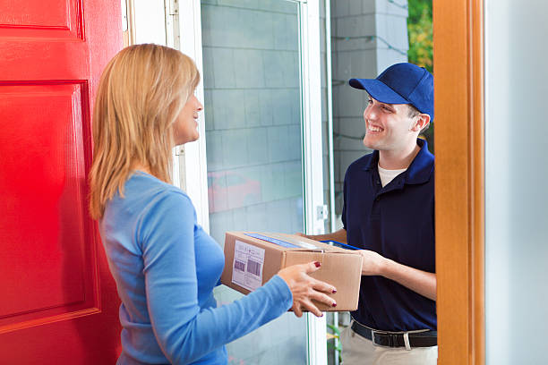 istock Delivery Person Delivering Package Box Container to Home Customer 498528028