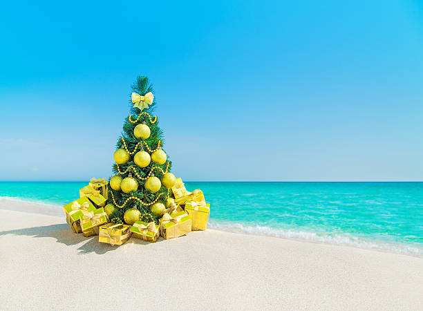 istock Christmas tree with golden decorations and gift boxes at beach 498528378