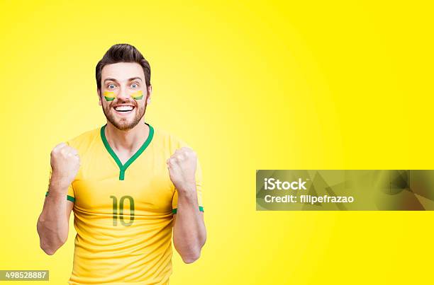 Foto de Brazilian Fan Celebra Em Fundo Amarelo e mais fotos de stock de Brasil - Brasil, Camiseta, Adulto