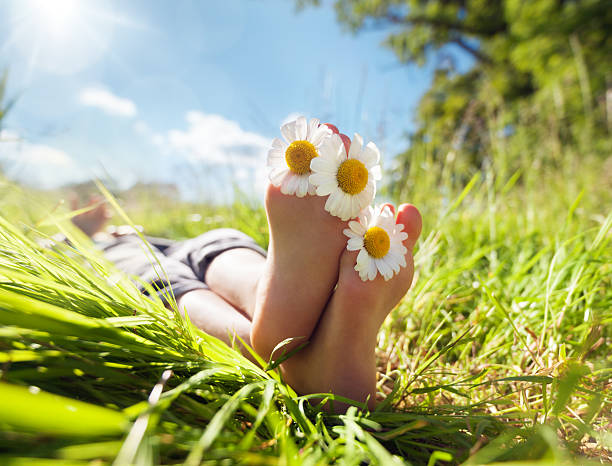 bambino sdraiato/a prato rilassante in estate di sole - human foot barefoot sole of foot human toe foto e immagini stock