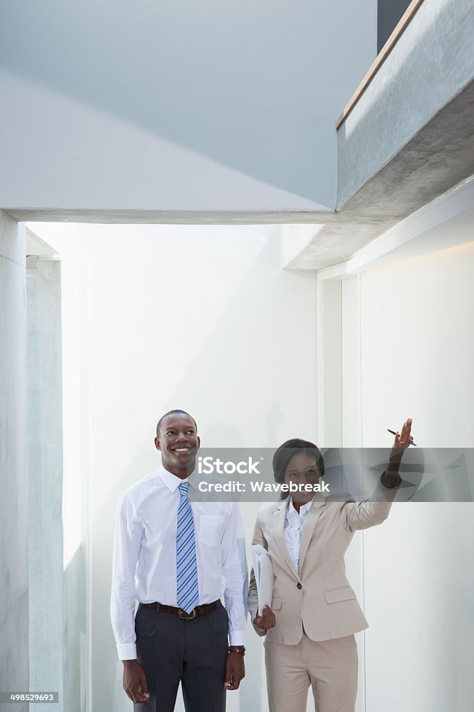 Estate agent showing buyer around Estate agent showing buyer around in a new house 20-29 Years Stock Photo