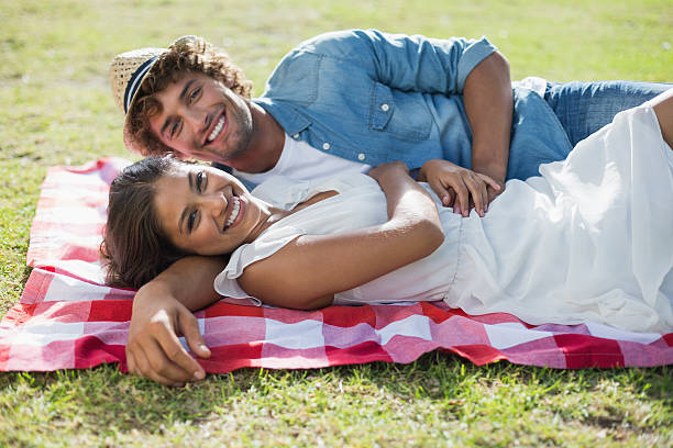 istock Hip young couple relaxing on a blanket in the park 498529709