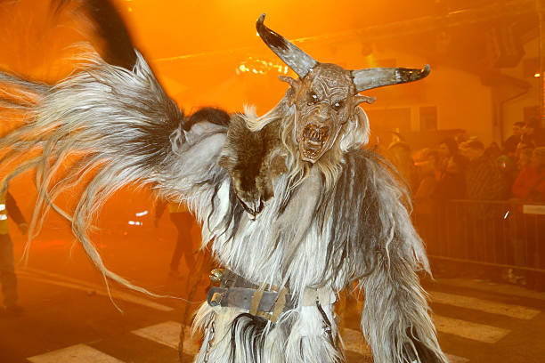Cesky Krumlov, Czech Republic - December 4 2022: Krampus or Cert Demonic Figure with Horned Mask at a Traditional Bohemian Krampus Run on Saint Nicholas Day in Czechia.