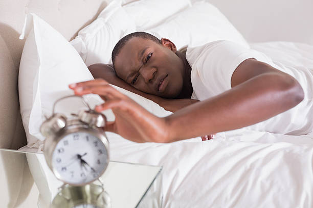 istock Grumpy man hitting his alarm clock in the morning 498529859