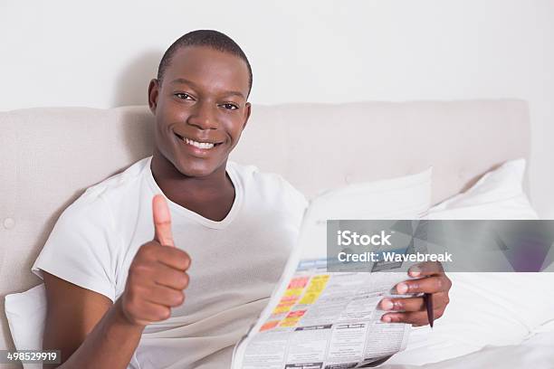 Happy Man Sitting Up In Bed With Newspaper Stock Photo - Download Image Now - 20-29 Years, Adult, Adults Only