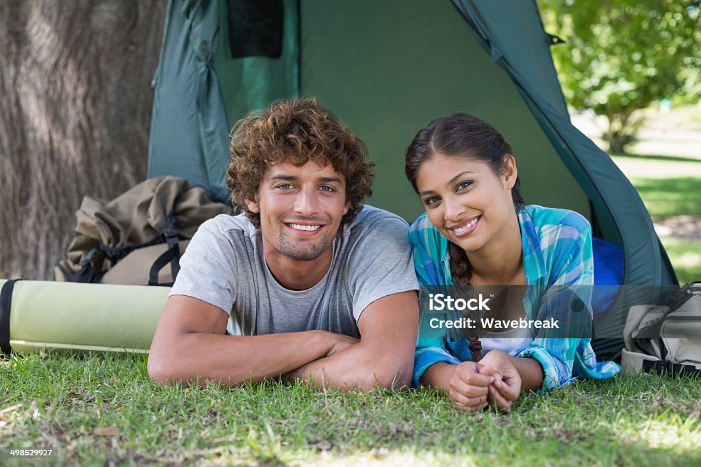 Young couple in their tent smiling at camera Young couple in their tent smiling at camera on a sunny day Camping Stock Photo