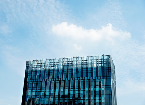 Modern glass office building against sky.