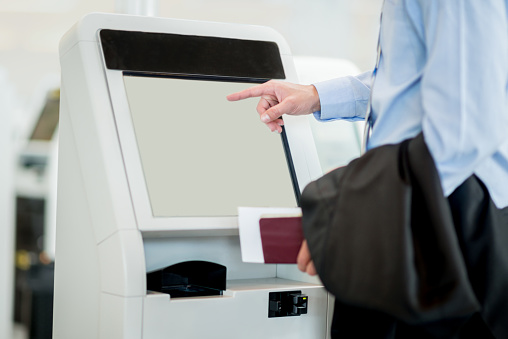 People traveling and printing boarding pass at the airport