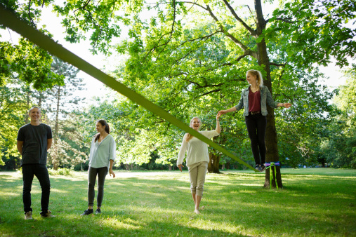 a group of friends standing beside, one girl helps with holding hand