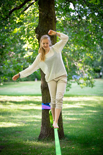 femmina adolescente in equilibrio su una slackline - tightrope balance walking rope foto e immagini stock