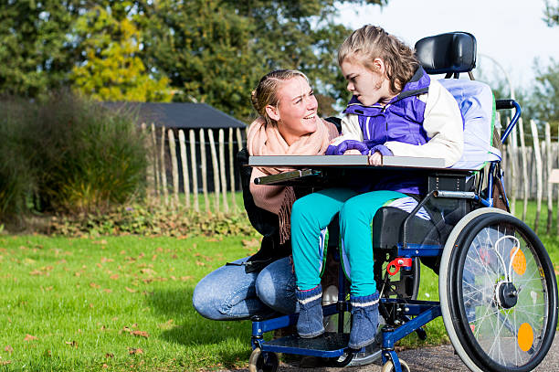 istock Disability a disabled child in a wheelchair relaxing outside 498530984
