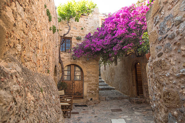 View of stone houses at Medieval fortress. Monemvasia, Greece - May 6, 2014: View of stone houses at Medieval fortress. Mainland and the rock on which the city is located, connected by a highway bridge in 1971. sparta greece photos stock pictures, royalty-free photos & images