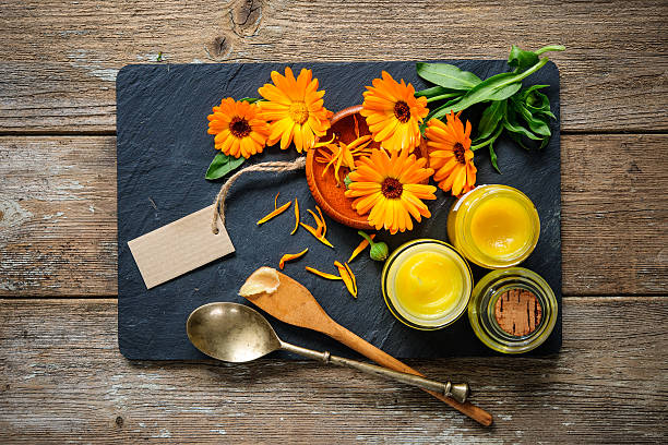 Homemade calendula ointment Homemade calendula ointment and oil pot marigold stock pictures, royalty-free photos & images