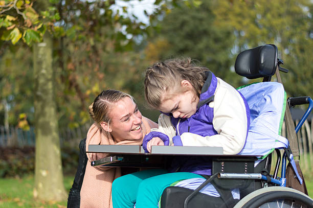 istock Disability a disabled child in a wheelchair relaxing outside 498532468