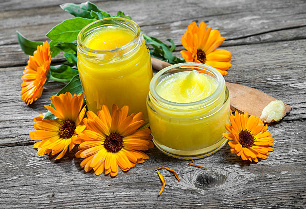 Homemade Calendula Ointment Homemade calendula ointment on wooden table ointment photos stock pictures, royalty-free photos & images