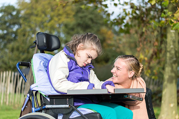 istock Disability a disabled child in a wheelchair relaxing outside 498534160