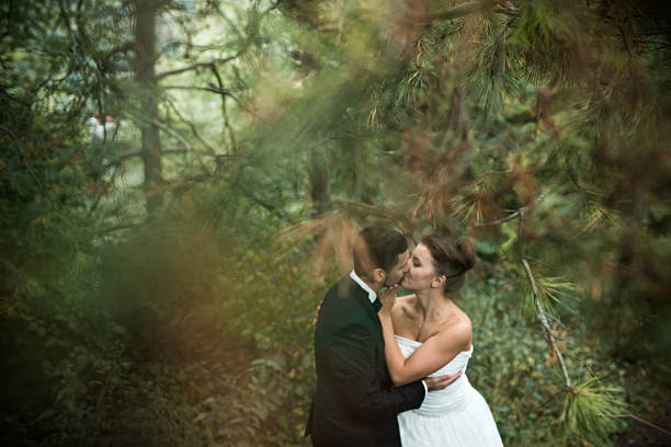 istock bride and groom dance together in the woods 498534840