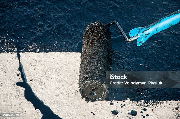 Roofer Worker Painting Black Coal Tar Bitumen Roller Brush   Waterproofing Stock Photo - Download Image Now