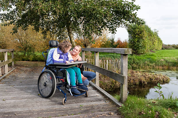 istock Disability a disabled child in a wheelchair relaxing outside 498536378