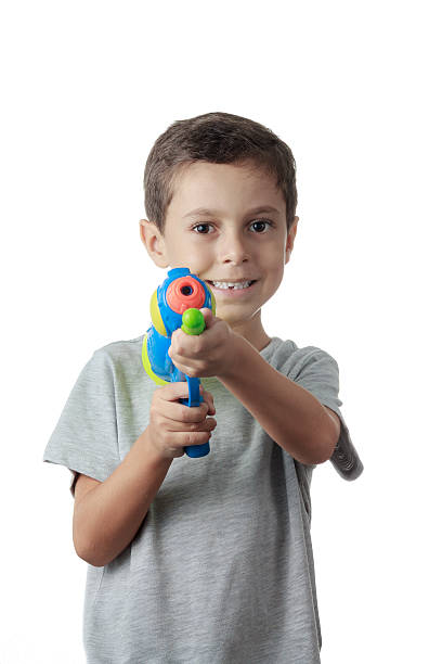 istock Little boy playing with plastic water gun isolated on white. 498546088