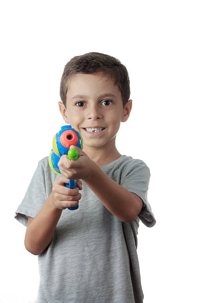 istock Little boy playing with plastic water gun isolated on white. 498546282