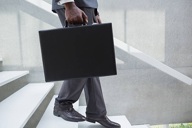 istock Businessman holding briefcase walking down stairs 498548927