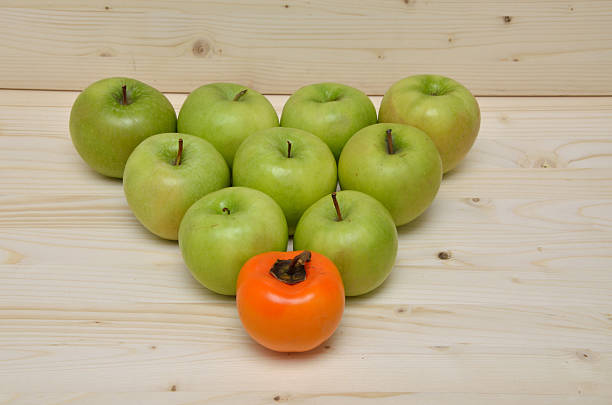 manzana verde y naranja kaki apple - individuality standing out from the crowd apple contrasts fotografías e imágenes de stock