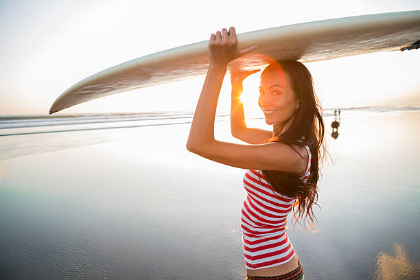 istock Surfer girl on the beach at sunset 498549577