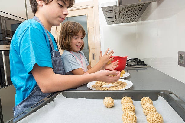 rodziny w kuchni przygotowując cukierki - glazed almond nut sugar zdjęcia i obrazy z banku zdjęć