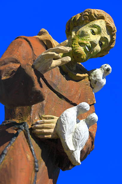 Williamsburg, Virginia, USA - June 7, 2025: The sun begins to warm a green moss covered statue on a grave in the Bruton Parish Cemetery.