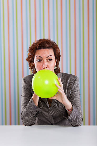 風船投げたビジネスウーマン - inflating balloon women growth ストックフォトと画像