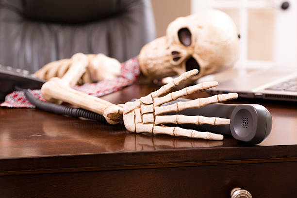 esqueleto de hombre que murió mientras espera "música de espera".  teléfono. - skull holding spooky horror fotografías e imágenes de stock
