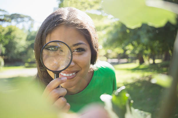 istock Environmental activist looking at camera through magnifying glass 498550997
