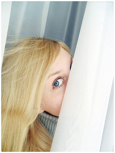 The head of a blonde woman showing through a hole in the wall.