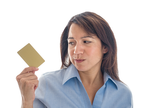 Photograph of a young mixed race woman looking warily at her credit card or gift card.